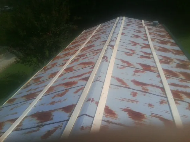 Rusted metal roof panels with new wood purlins before replacement — Storm Damage Roof Repair in Coram by Roofing Brothers