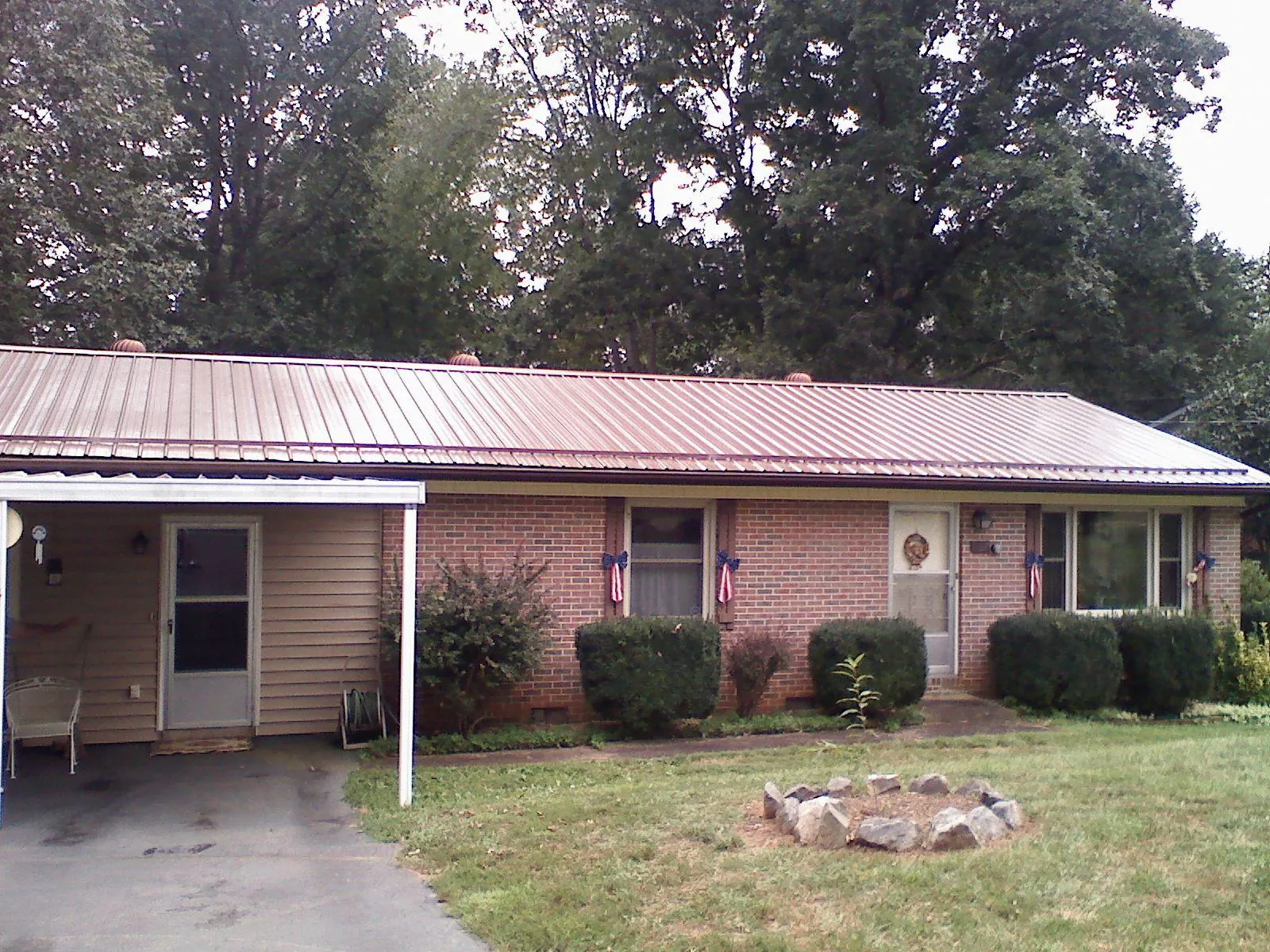 Bronze metal roof and carport on a brick ranch home — Roof Repair work by our crew in Coram